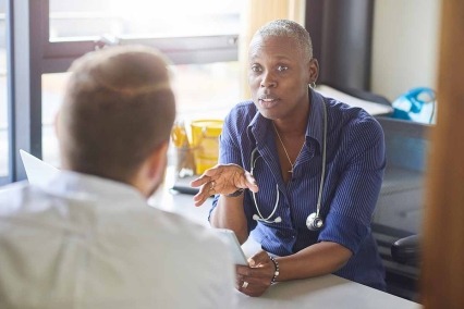 El médico se reúne con el paciente en el consultorio.